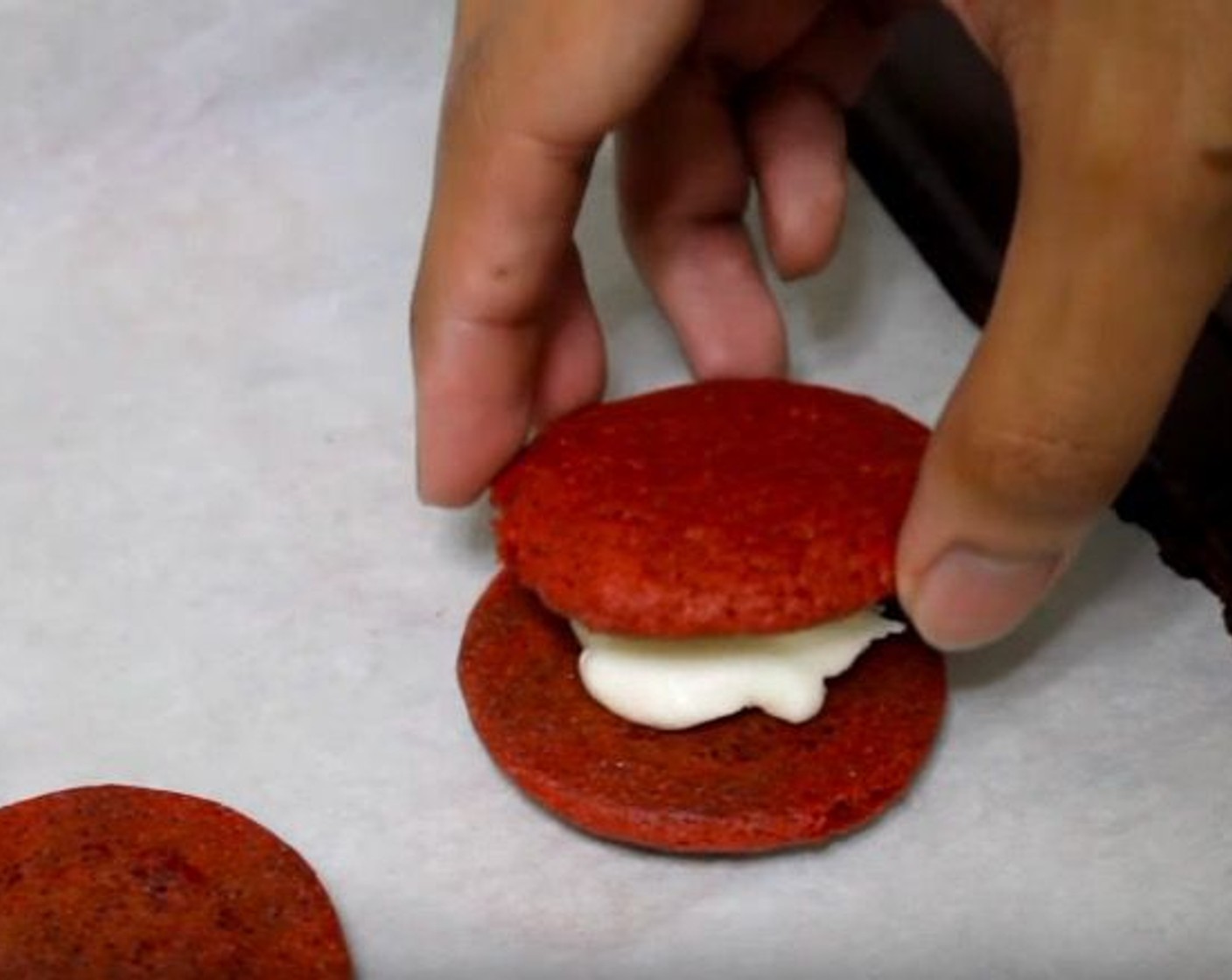 step 8 Place spoonfuls of cream cheese frosting on half of the cookies and place another cookie on top.