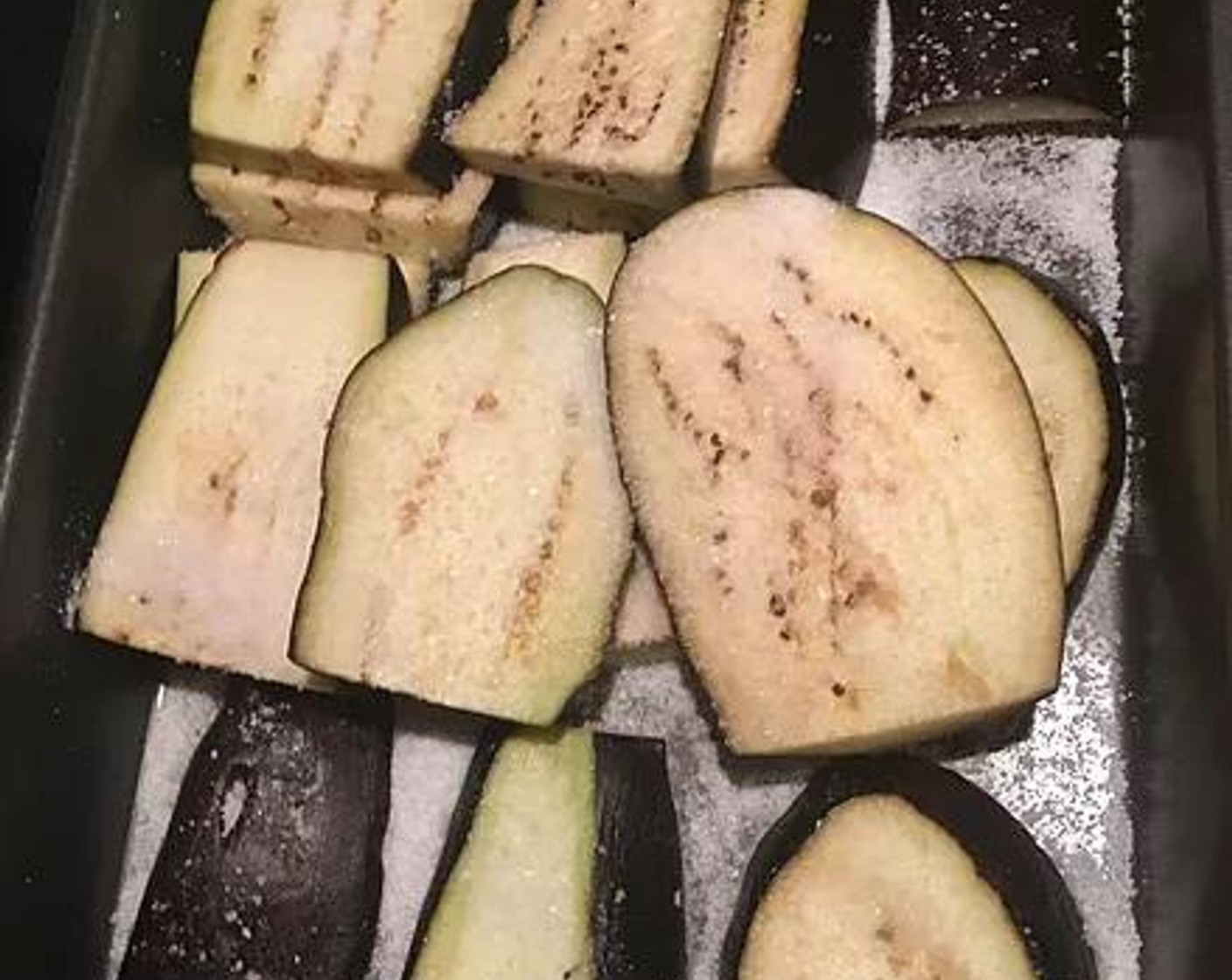 step 1 Cut the Eggplants (2) lengthwise.  In a shallow baking dish, salt each side of the eggplant heavily and let it sit out for a few hours or in the fridge overnight. This draws all the moisture out of the eggplant and allows for a crispier texture when we will cook it lat.