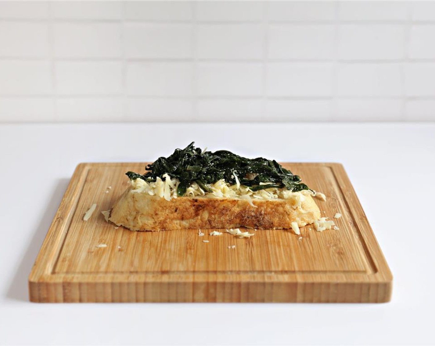 step 3 Place butter side down on the cutting board. Top unbuttered side of the bread with Gruyère Cheese (1/3 cup) and add the Spinach.