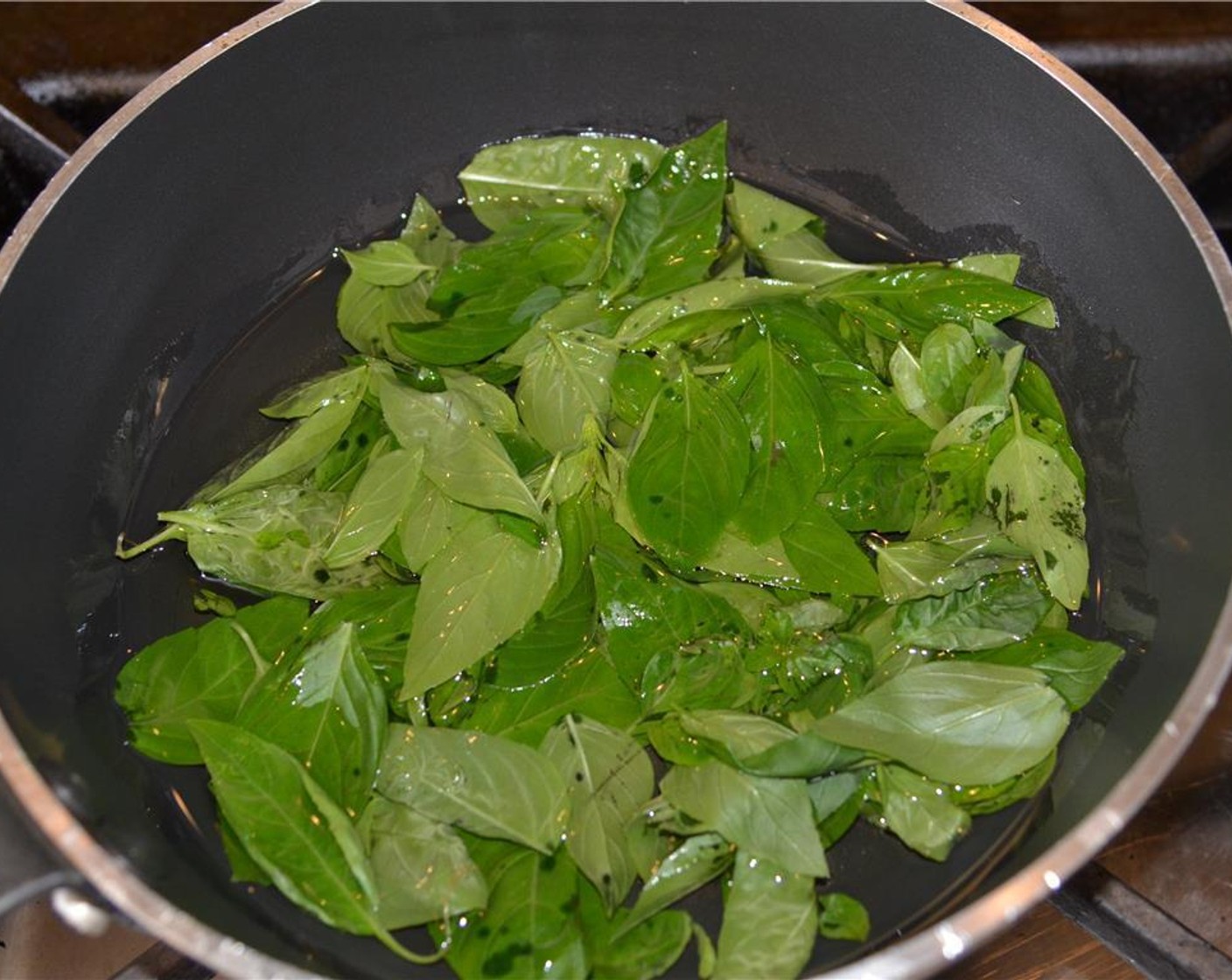 step 4 Remove the stems from the Fresh Basil (2 bunches) and place the leaves in a sauté pan and cover with Vegetable Oil (as needed).