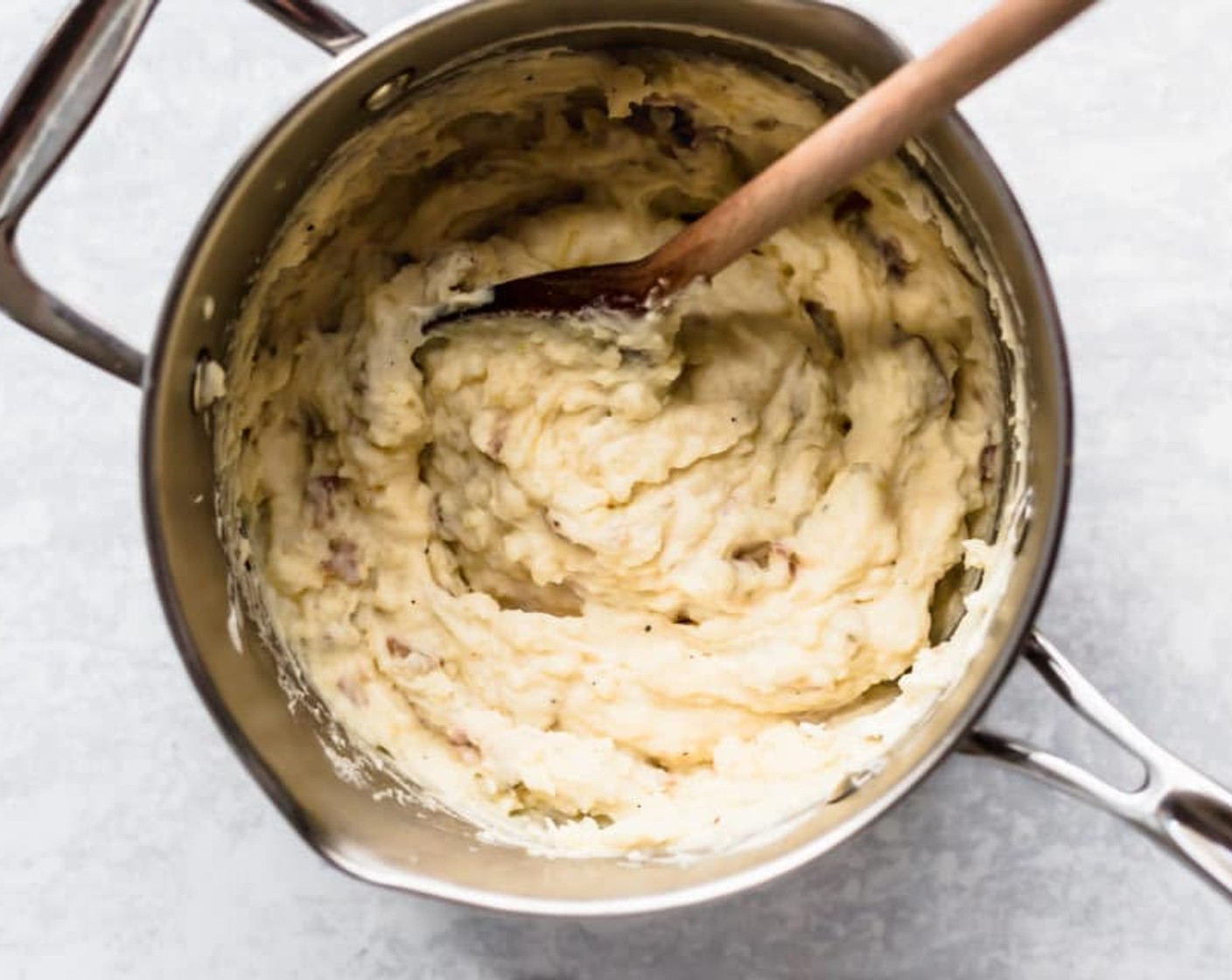 step 2 Drain and return to the saucepan with Light Sour Cream (3/4 cup). Mash to desired consistency. Stir in the Shredded Cheddar Cheese (1/4 cup).