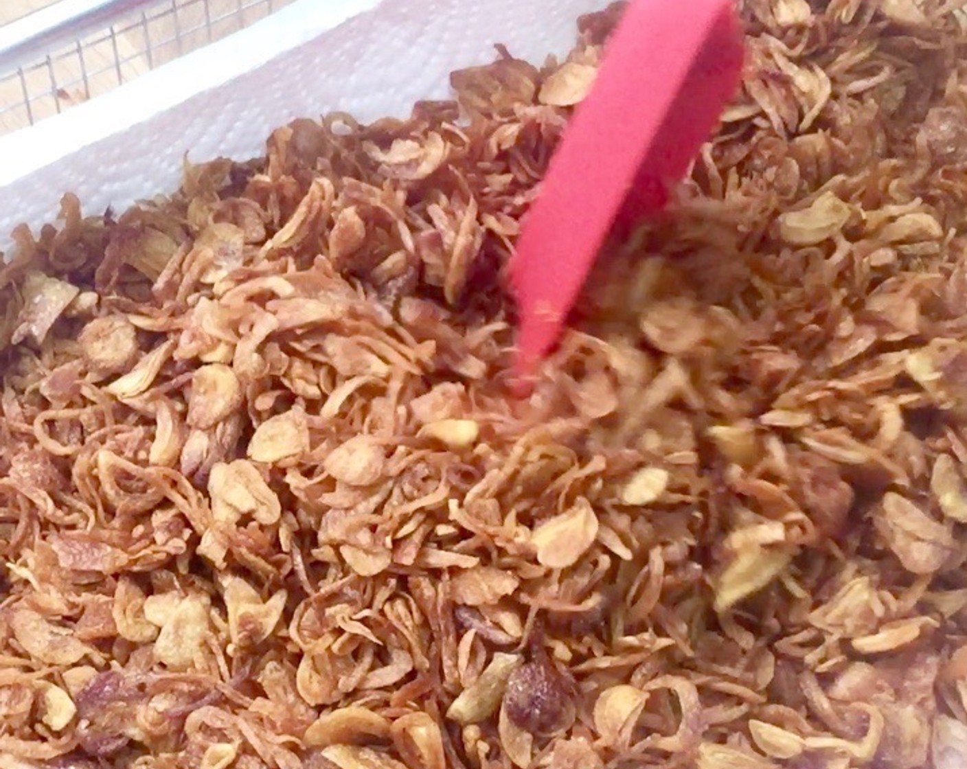 step 7 Transfer to a paper towel lined tray to remove excess oil. Using a spatula, lightly even out the fried shallots to minimise overlapping.