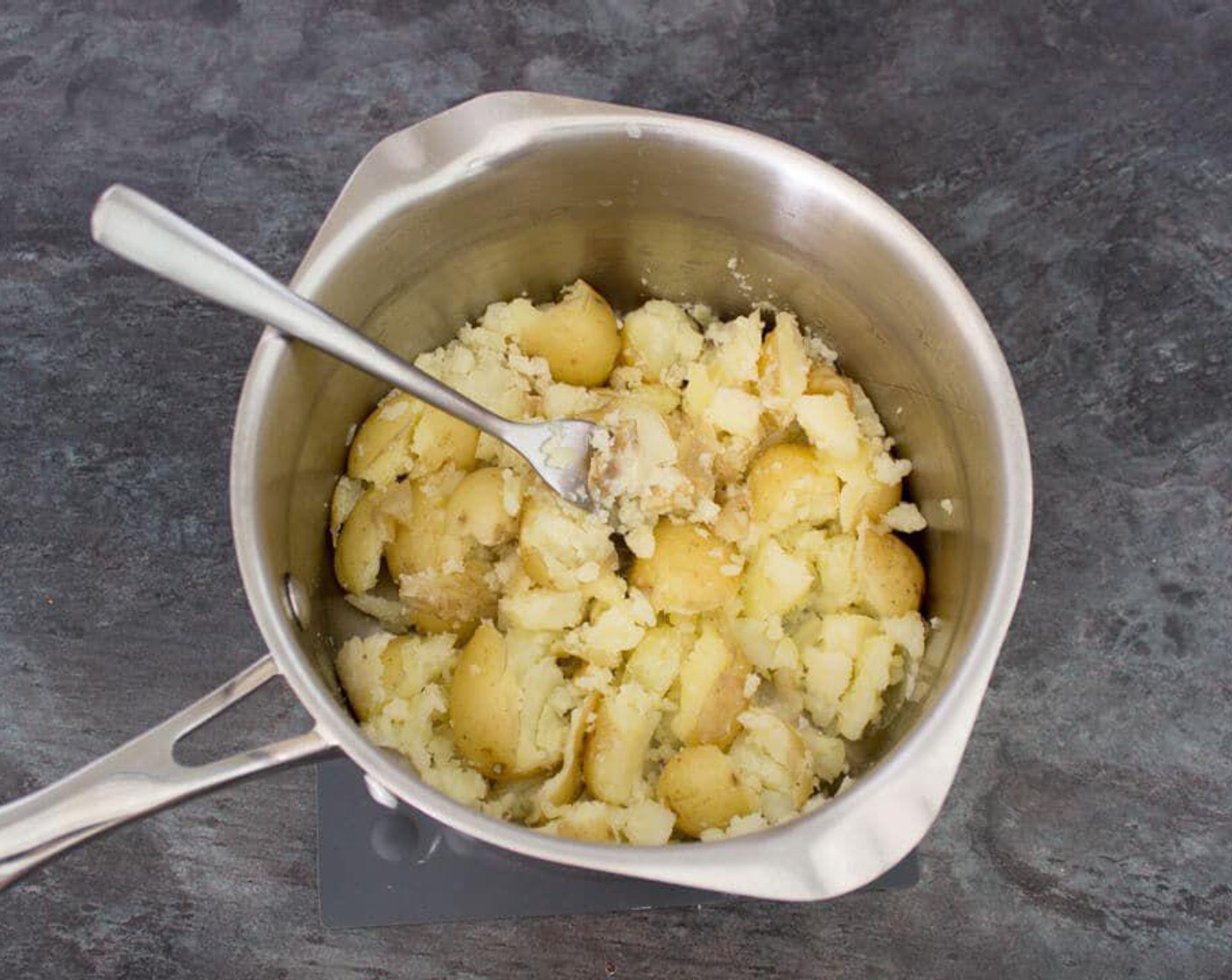 step 2 Drain the potatoes well then gently crush with a fork. You want a good mix of large & small chunks.