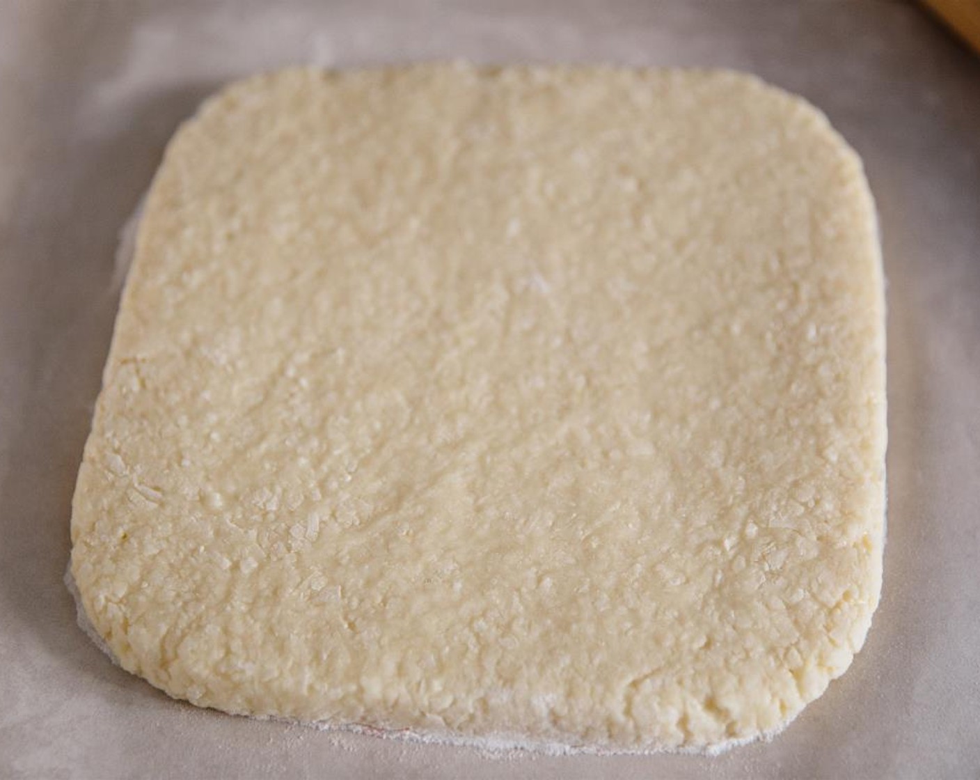step 9 On a piece of baking paper, roll out and shape the white coconut ice layer into a square, about 3/4 inches thick