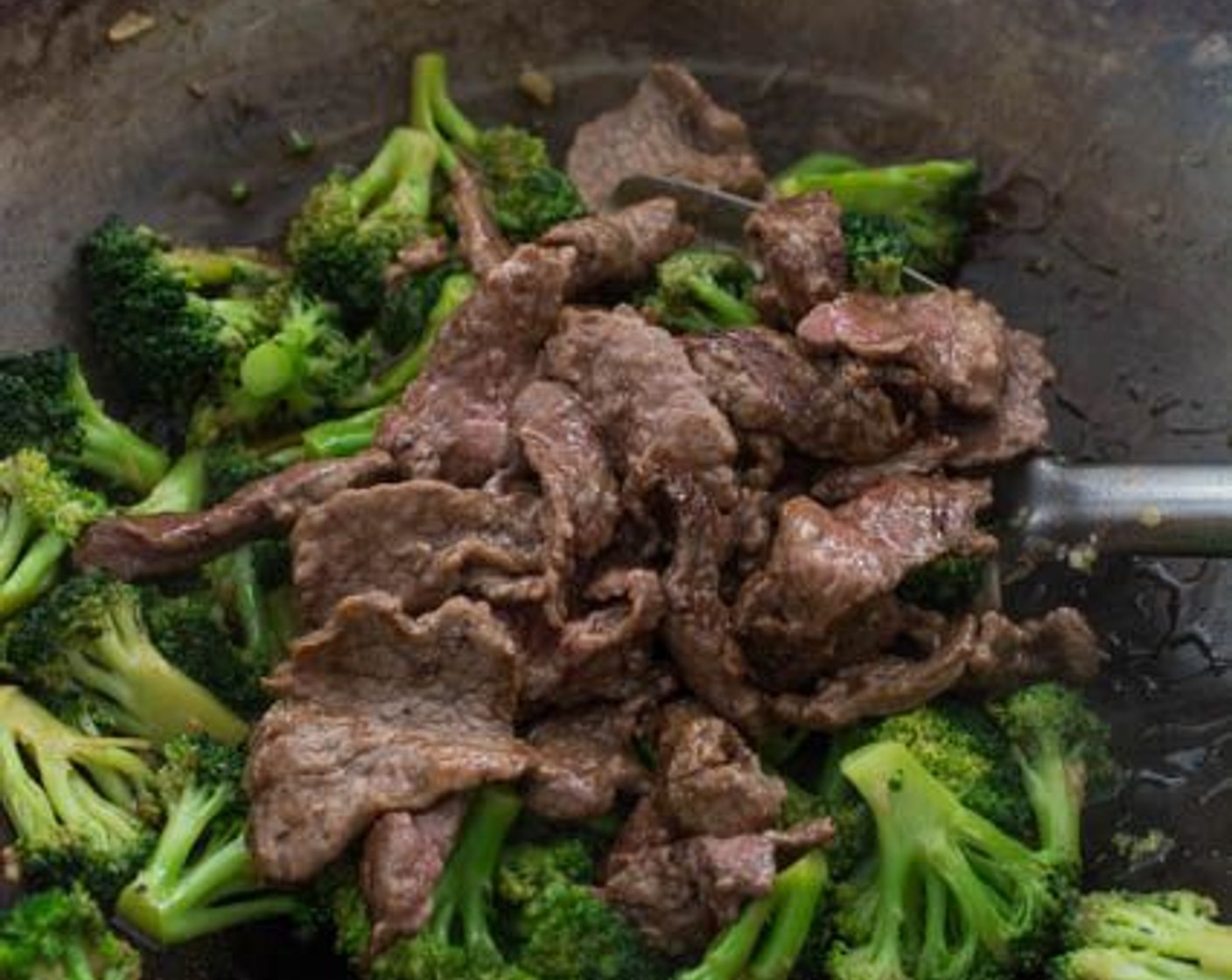 step 7 As soon as the sauce thickens, return the beef to the wok and give it a final stir before transferring the dish to a serving bowl.