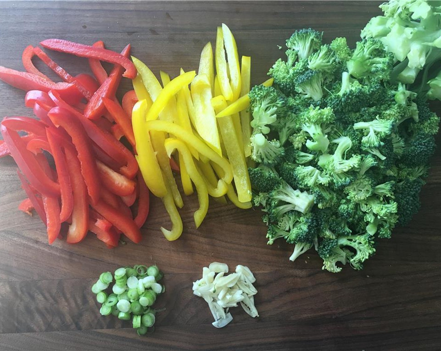 step 3 While the rice is cooking, slice the Bell Peppers (2) and Garlic (3 cloves). Chop the Broccoli (1 head) into florets. Thinly slice the white part of the Scallion (1 bunch) and set them aside for garnish later.