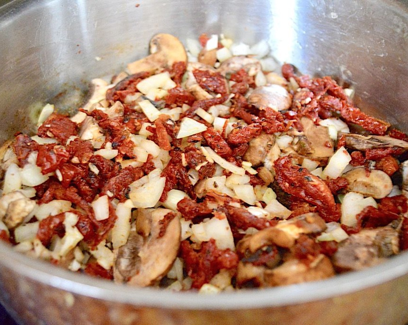 step 3 Transfer it to a plate, then add Sun-Dried Tomatoes (1 jar), Cremini Mushroom (1 cup), Onion (1), and Garlic (4 cloves) to the pan. Let them cook and get fragrant for about 3 to 4 minutes, then transfer them to the plate with the chicken.