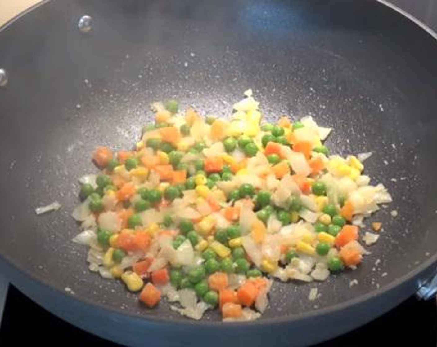 step 2 Grease wok one more time, and add in the Yellow Onion (1), Garlic (1 clove) and Frozen Mixed Vegetables (1 cup).Cook everything well together.