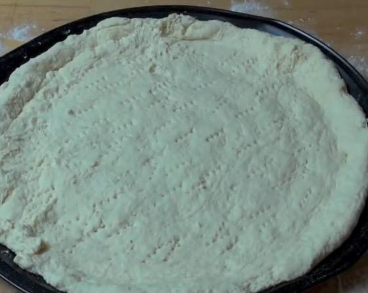 step 2 On a floured surface, gently knead the dough until it is smooth. Roll it out into a pizza shape and transfer onto a large oven tray. Prick with a fork across the surface to prevent rising.