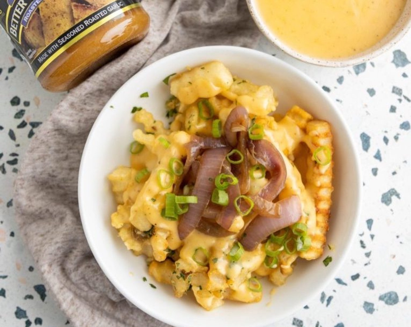 step 7 Split evenly amongst two bowls and top with the masala cheese sauce and sauteed onions. Sprinkle on some Scallion (1 bunch) and enjoy!