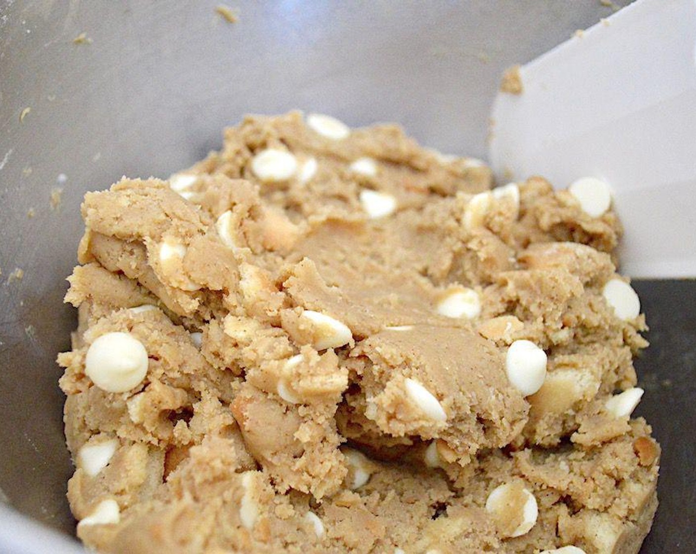step 3 Then add in the Vanilla Extract (1 tsp) and Eggs (2) and let them get thoroughly mixed in. Finally, slowly add in the dry ingredients until a dough forms. Turn the mixer off and switch to a spatula to fold in the chopped Vanilla Wafers (1 cup) and White Chocolate Chips (3/4 cup).