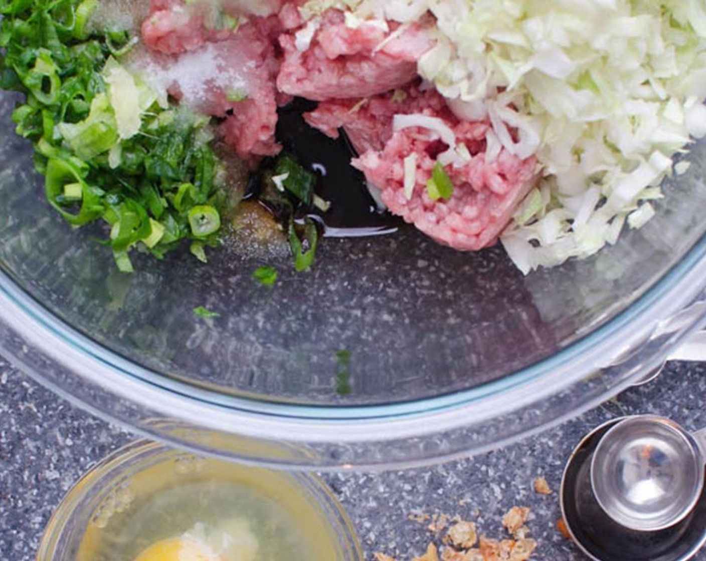 step 1 Peel and grate the knob of Fresh Ginger (1 in). In a large bowl, combine Dried Shrimp (1/2 Tbsp), Sherry Wine (1/2 Tbsp), Green Cabbage (1 1/2 cups), Kosher Salt (1/2 tsp), Ground Pork (1 lb), Fresh Chives (1 bunch), Garlic (1 clove) and ginger.