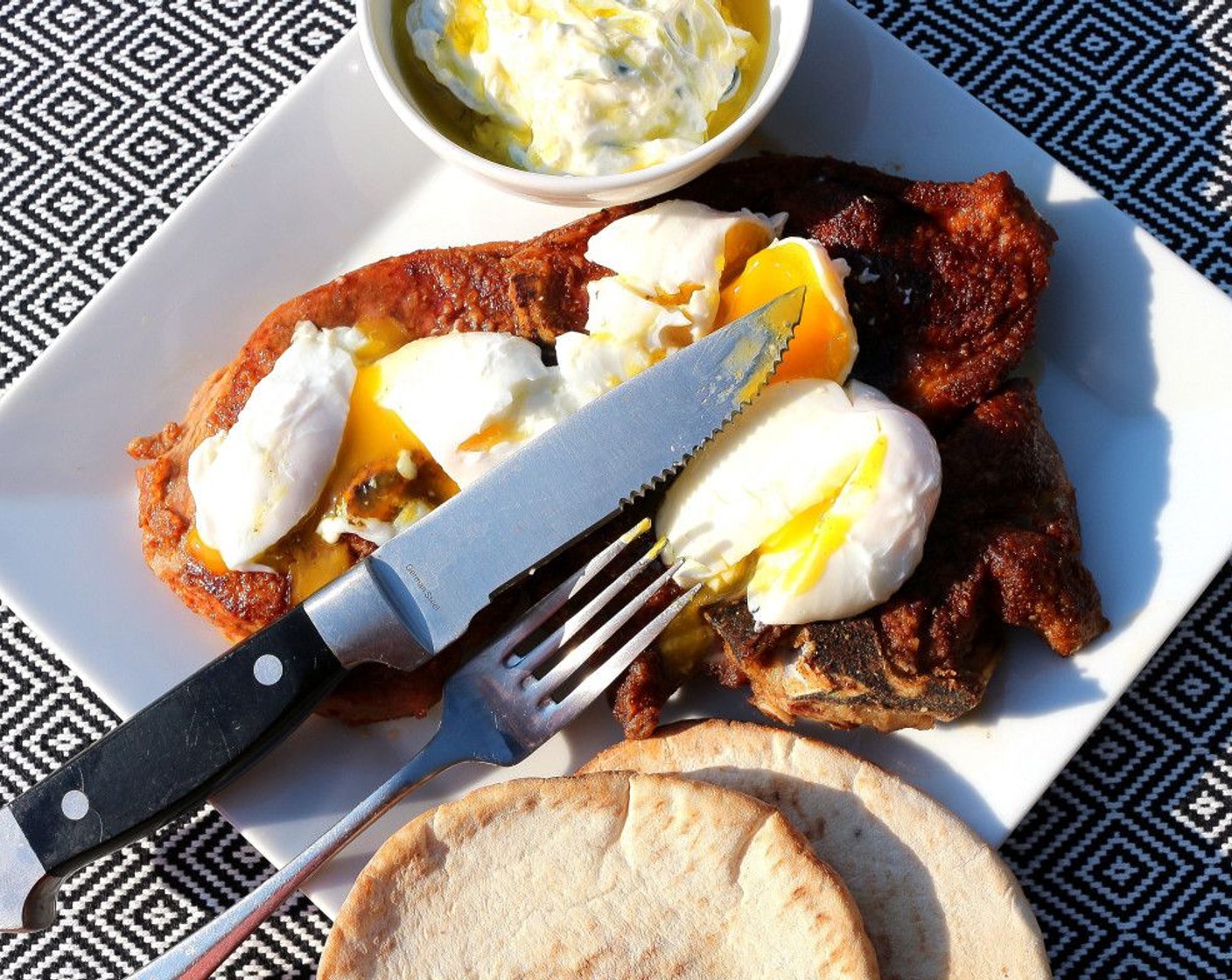 step 8 Top the steak with poached eggs, serve with tzatziki, drizzle with plenty of Extra-Virgin Olive Oil (to taste) and warm pita. Enjoy!