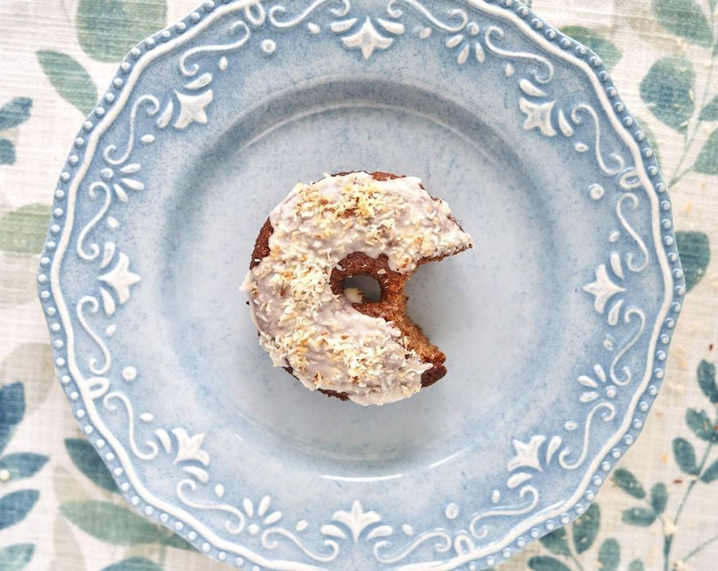 step 8 Spoon the melted coconut glaze over top of each donut. Sprinkle toasted coconut shreds on top.