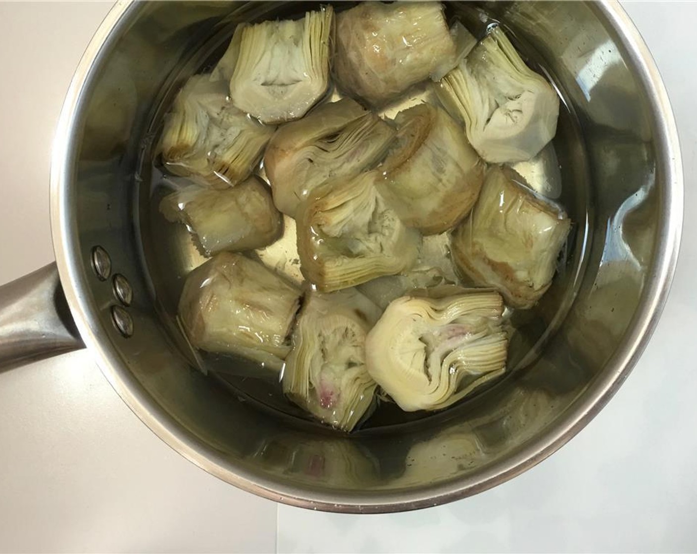 step 2 If you are using fresh Baby Artichokes (6) clean and trim them first. Then add the cleaned fresh artichokes or the frozen artichokes to a large saucepan and add water until the artichokes are fully submerged. Season with a pinch of Salt (to taste).