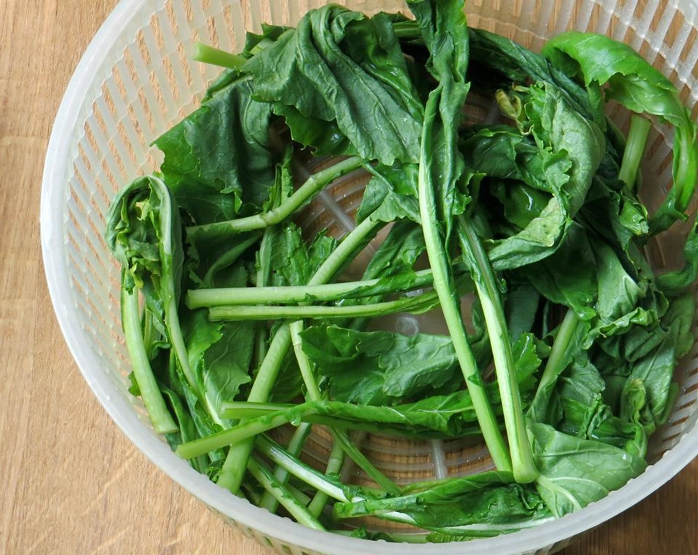 step 2 Place the stems in a bowl of water. Swish around to remove any sand or dirt from the leaves. Transfer the greens to a salad spinner and dry them. Set aside.