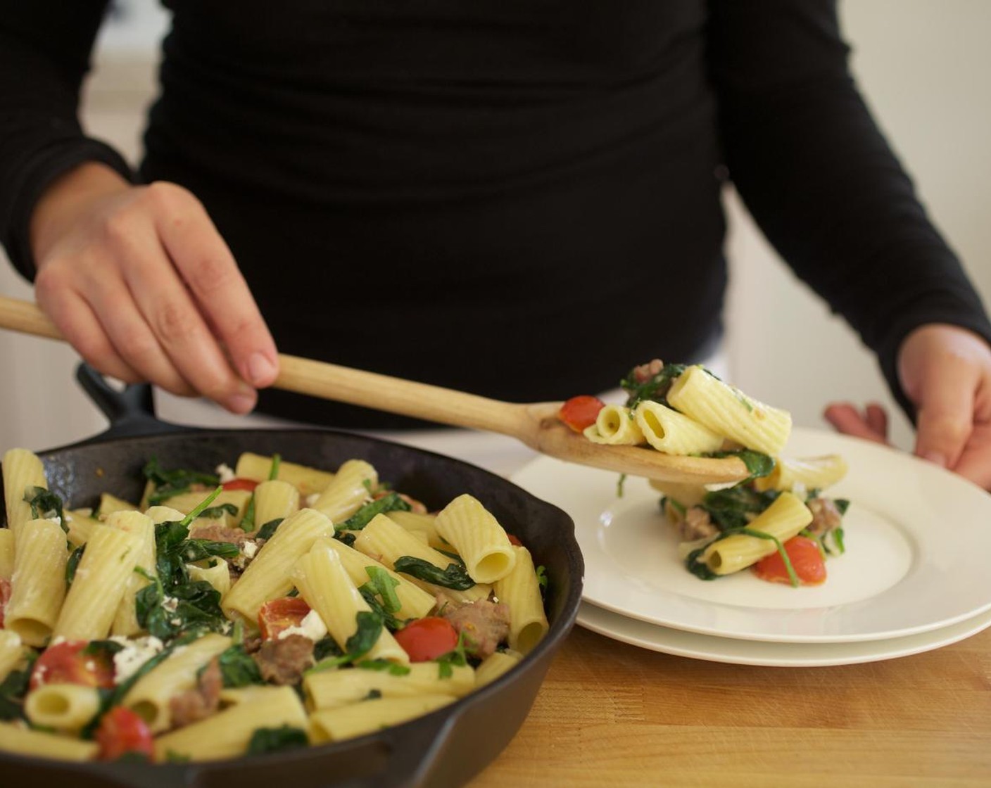 step 10 Evenly distribute the pasta between two plates. Top with remaining Goat Cheese (4 Tbsp) by crumbling the cheese with your fingers.