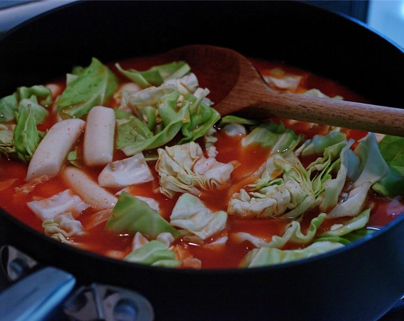 step 13 Place the pan over medium heat. Add rice cakes and cabbage.