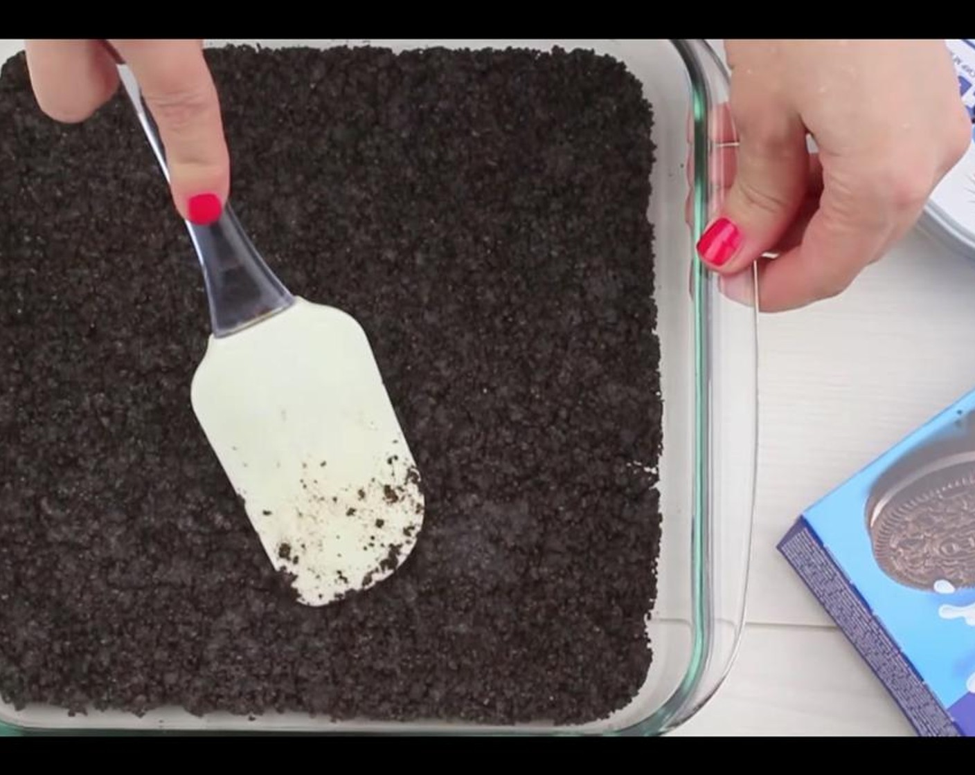 step 5 Spread half of mixture in 8x8 or 9x9 inch square baking pan and press with your fingers or some firm object to form a crust layer. Save the rest of the Oreo crumbs for later. Set aside.