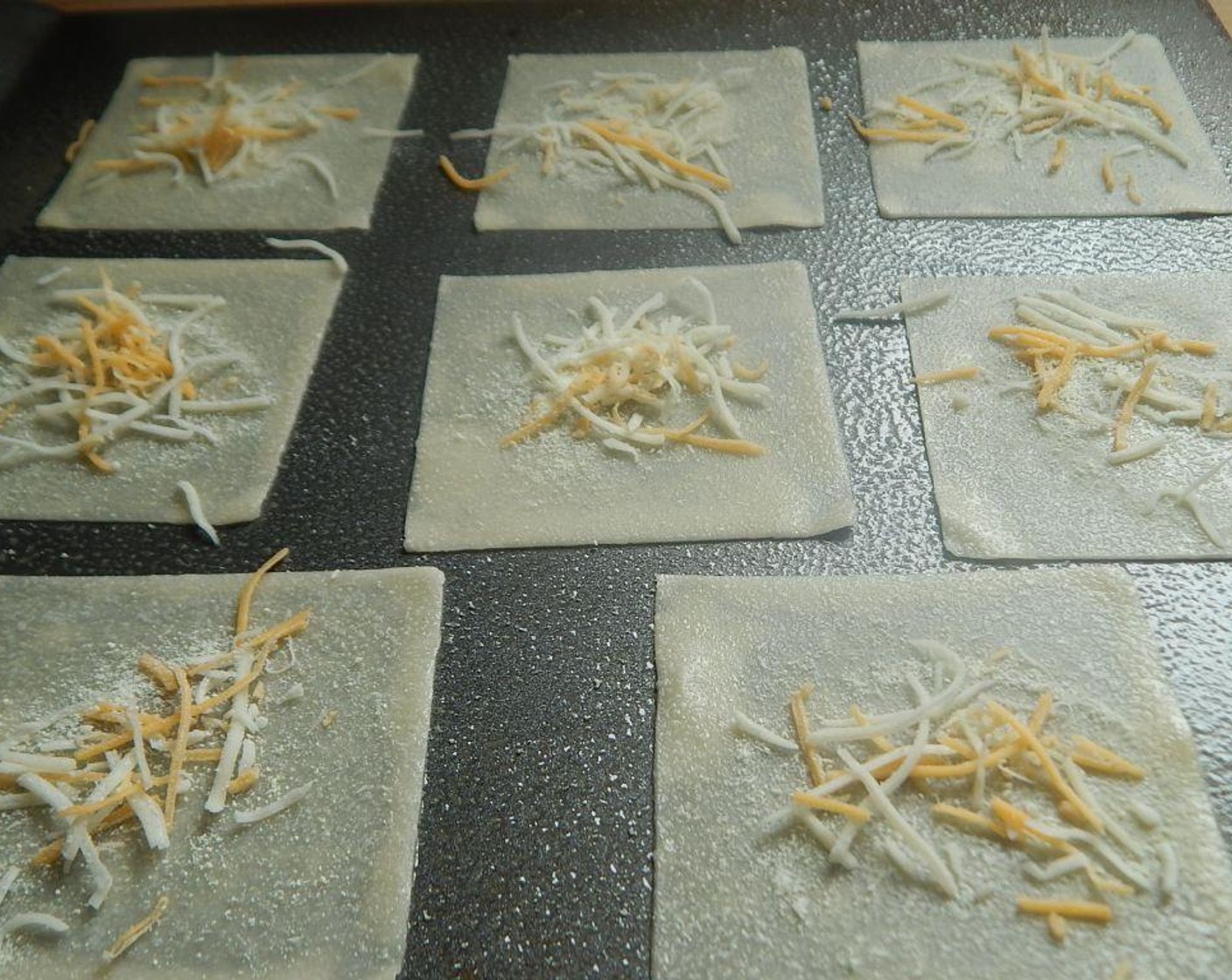 step 3 Lay out your wontons (make as many as you wish). Spray the tops of the Wonton Wrappers (1 pckg). Sprinkle a little bit of Light Shredded Cheese Blend (to taste) and Grated Parmesan Cheese (to taste) on top, you don't need much at all.