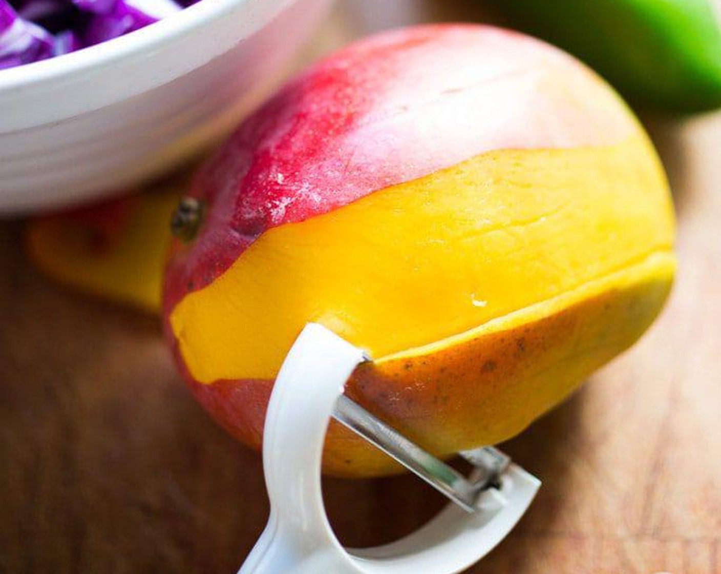 step 4 Peel Mango (1) with a vegetable peeler, then slice into thin strips, cut in half or thirds, place in the bowl.