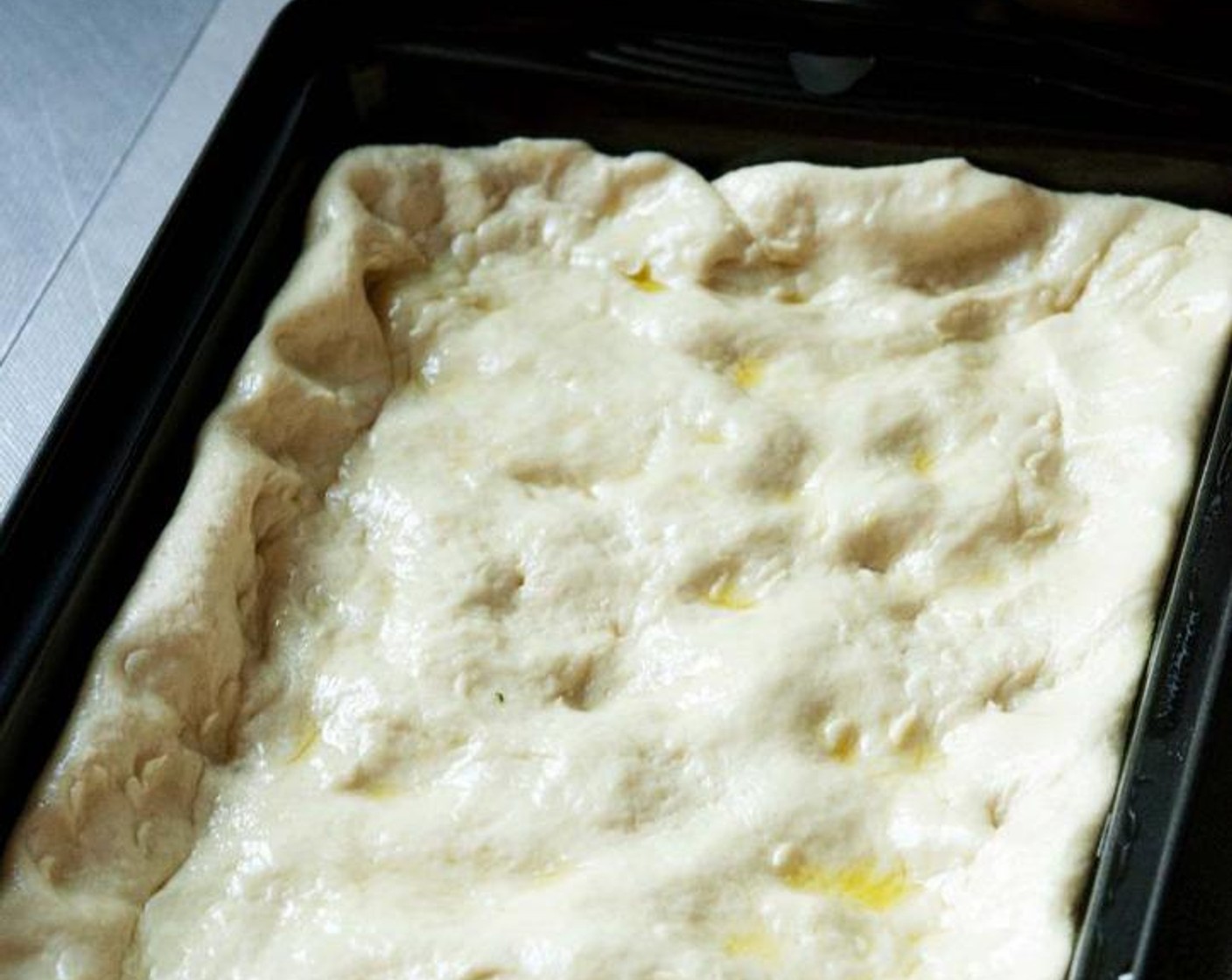 step 4 Grease a baking tray, and press the dough making sure it reaches out all the corners and edges of the tray.