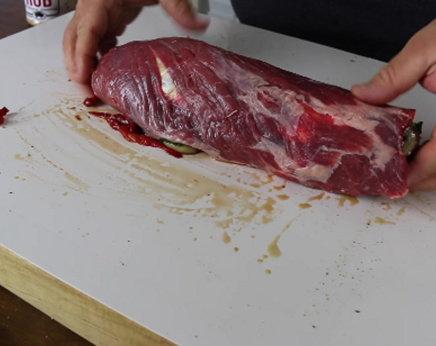 step 6 Tightly roll the flank steak using your fingers to keep the stuffing inside. Leave it seam down on the cutting surface.