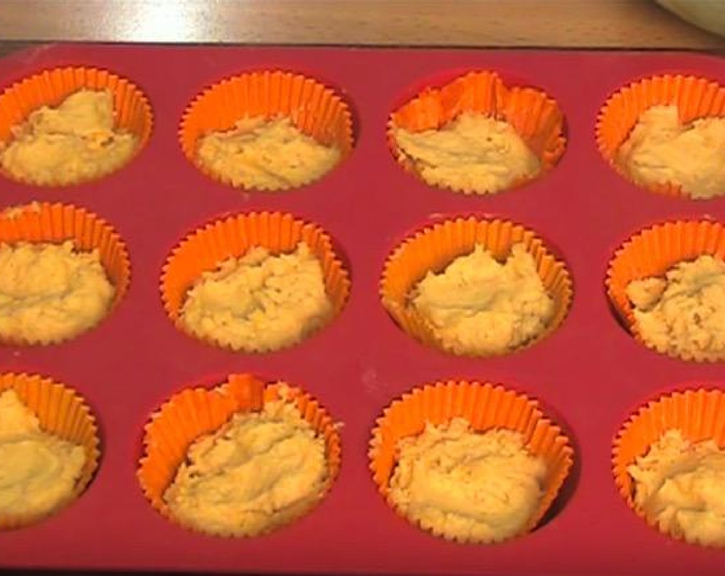 step 5 Transfer 2 tablespoons of batter into each hole of a 12-hole muffin tin lined with cupcake cases.