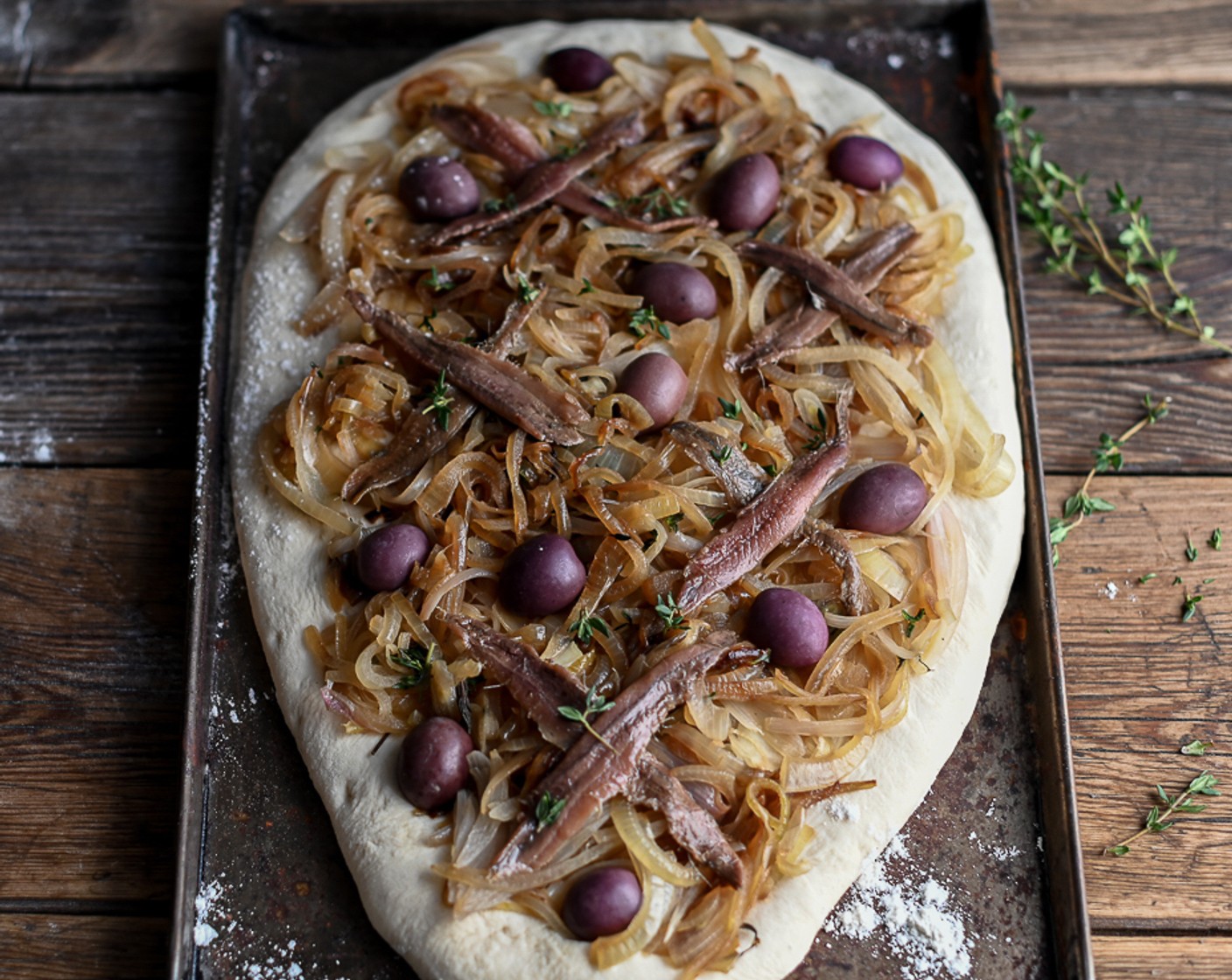 step 8 Carefully remove the Anchovy Fillets (8) from their oil and arrange them in a criss-cross pattern over the shallots. Dot the Kalamata Olives (1 cup) in between and drizzle over a little Olive Oil (as needed).