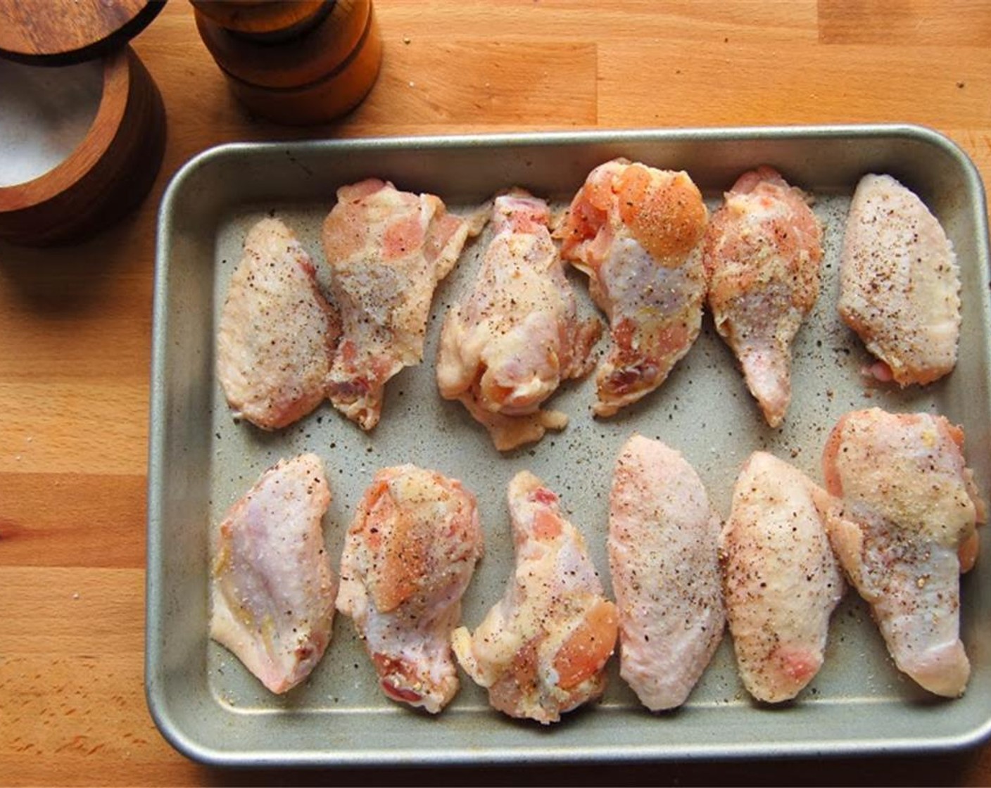 step 3 Toss the Chicken Wings (16) in a bowl with salt and pepper. Place on a baking tray. Put the wings on the pan in a single layer. Roast for about 25 minutes at 450 degrees F (230 degrees C).