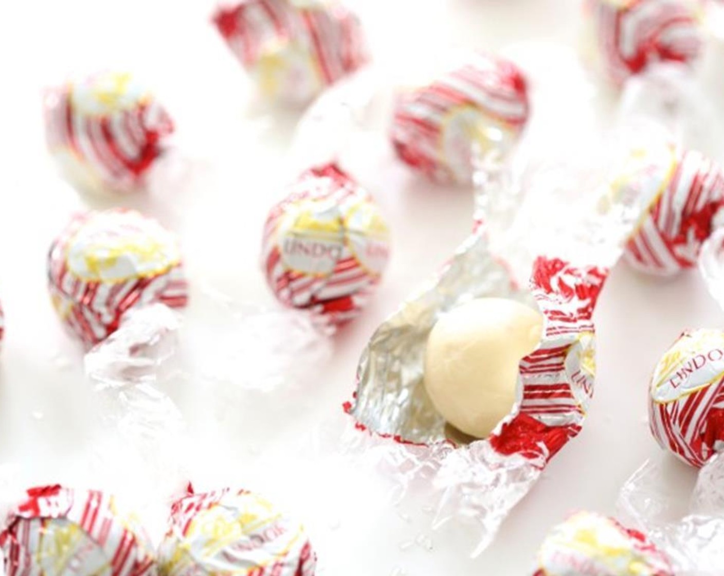 step 4 Remove saucepan from heat and begin to dip the tops of the Lindt LINDOR® Peppermint White Chocolate Truffles (12) into the white chocolate.