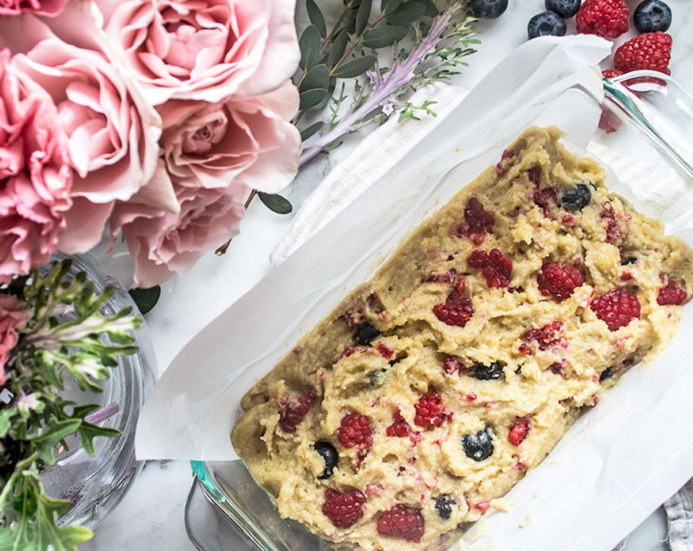 step 6 Pour batter into prepared loaf pan, spread evenly, and top with a few remaining blueberries and raspberries.
