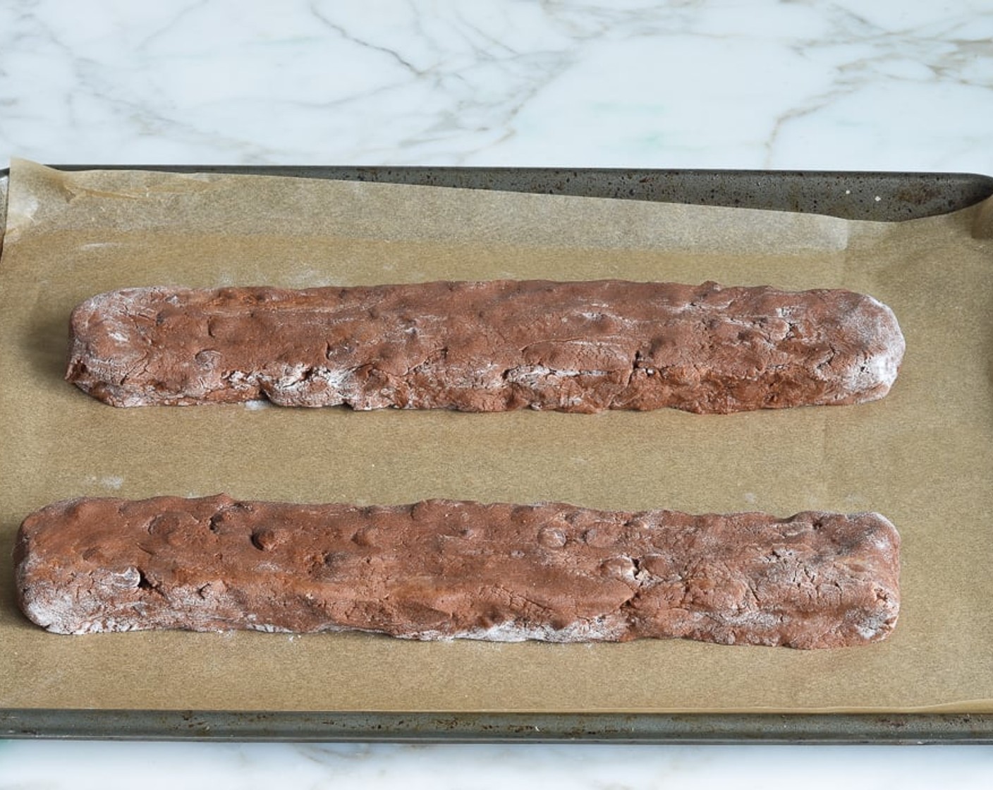 step 8 Place the logs onto the prepared baking sheet and shape into longer logs about 3/4 inch high and 2 inches wide. Allow enough space for the logs to spread a few inches while they bake.