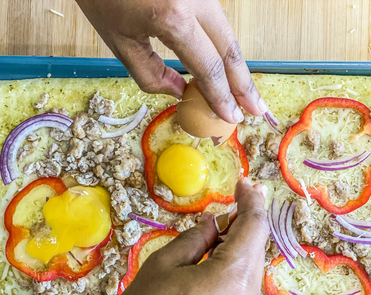 step 7 Evenly add the Red Bell Pepper (1), Breakfast Sausage Links (4), 1/2 the Red Onion (1/4), and crack an Eggs (5) inside each bell pepper.