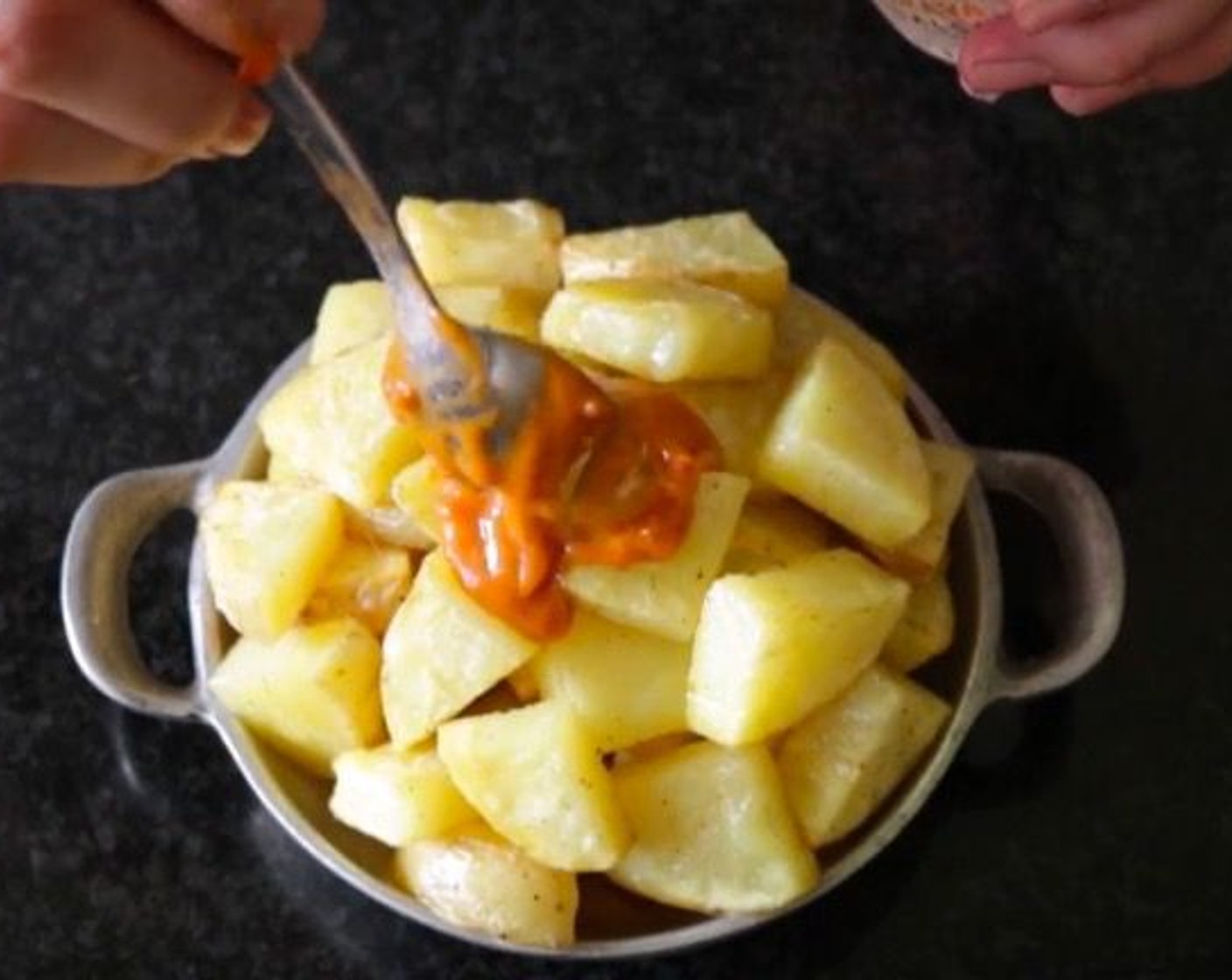 step 15 Once the potatoes are cooked through, remove them from the oven and transfer them to a shallow serving bowl. Add Salsa Brava (2 Tbsp) to the top of the potatoes.