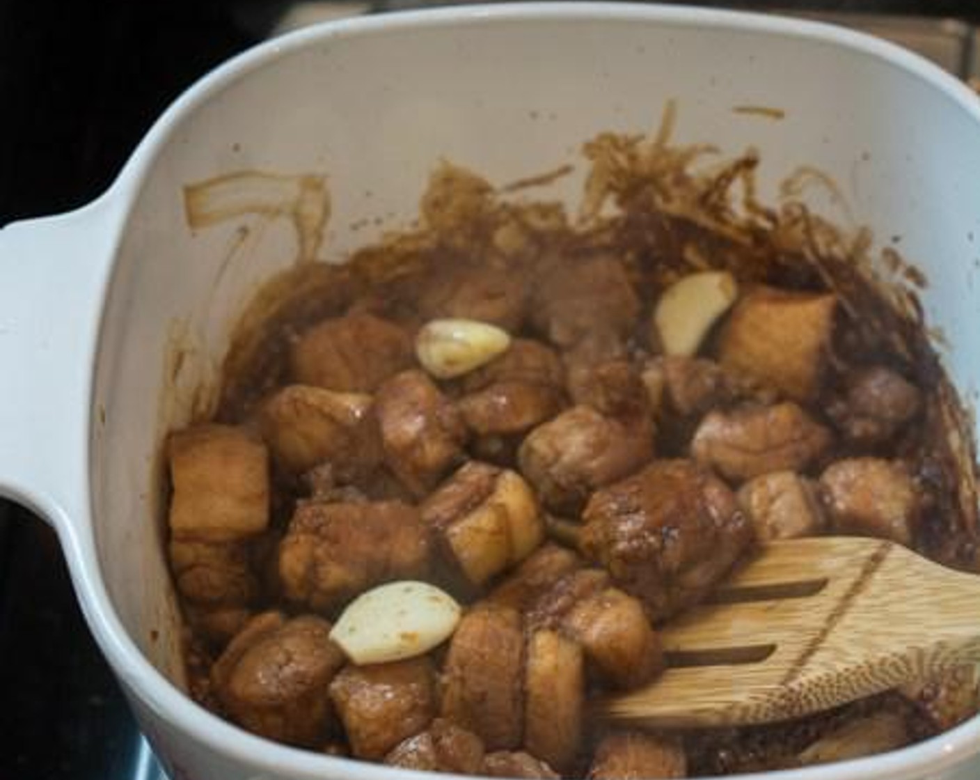 step 5 Fry the pork along with the marinade liquid in a large pot over medium-high heat. When the outsides of the pork is cooked, add Garlic (3 cloves) and the soy sauce broth.