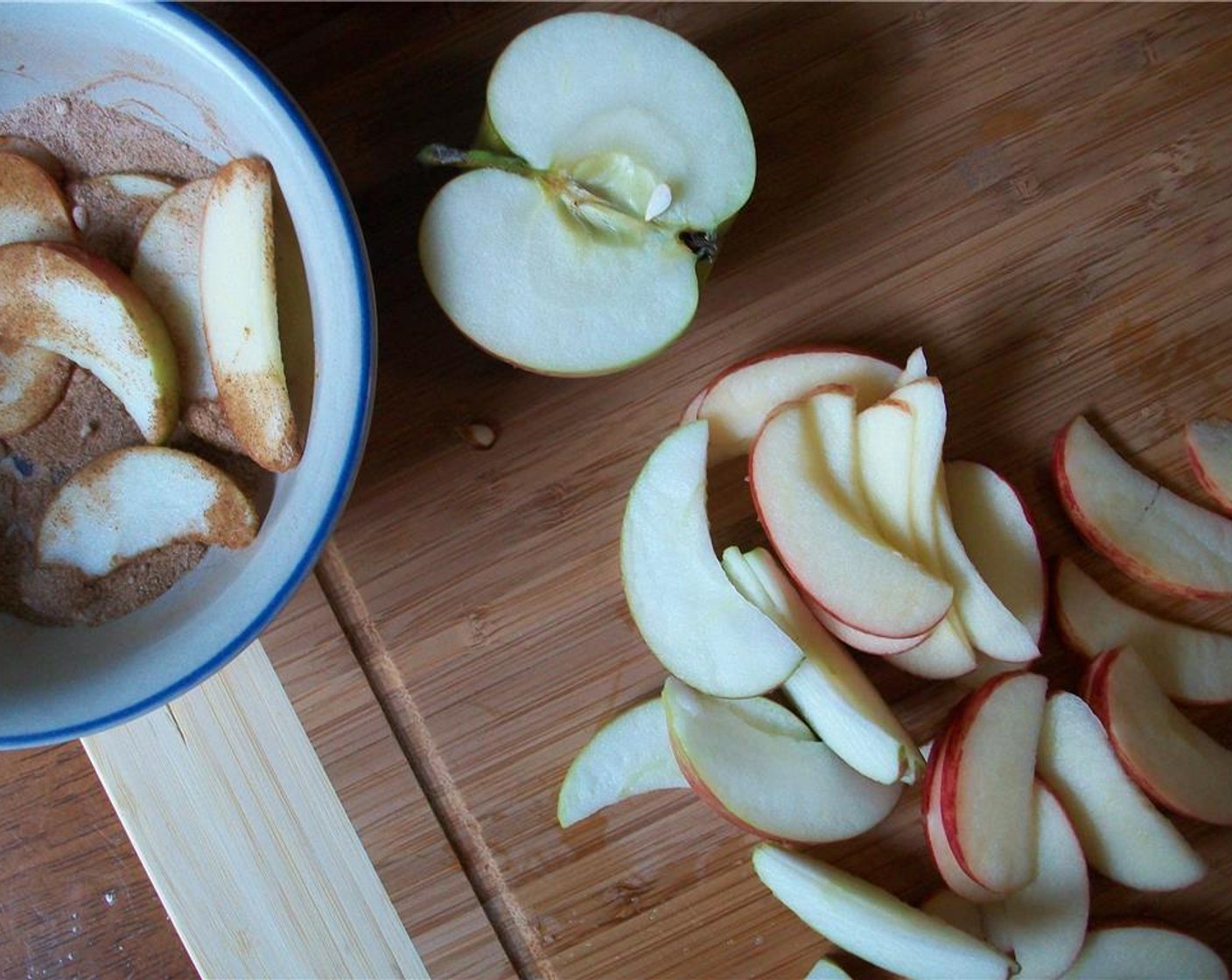 step 4 Spread half of this mixture into a seasoned cast iron skillet or your choice of greased pan. Place apples in a bowl and mix with Granulated Sugar (1 tsp) and a third of the Cinnamon (3 teaspoon).