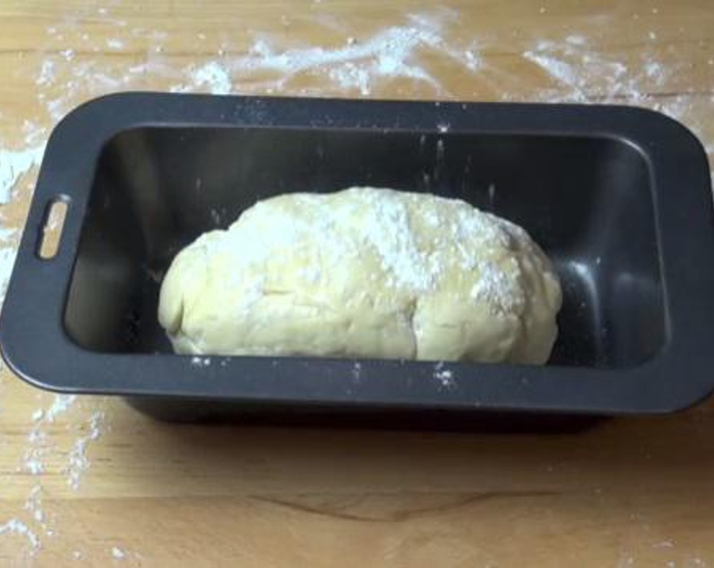 step 6 Place the dough on a floured surface again and kneed it for a few minutes. Then, form the dough into a loaf shape. Place it into a loaf tin, and brush the Egg (1) over the top. Sprinkle some flour on the surface.
