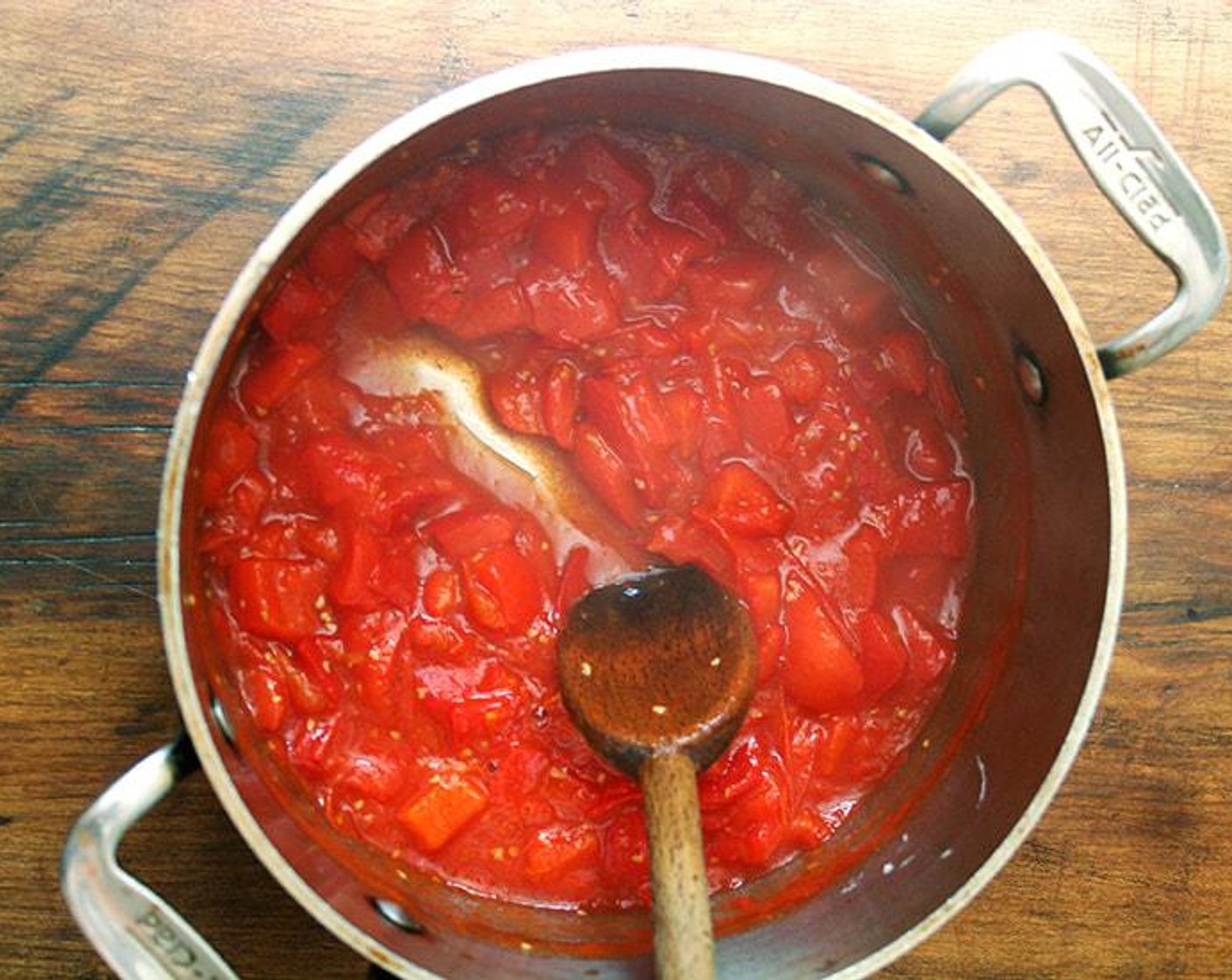 step 2 After about 5 minutes, the tomatoes and peppers will begin to release their juices, and the whole mixture should be bubbling. Adjust the heat if necessary so that the mixture stays at a constant bubble. Stir every 5 minutes or so to make sure the tomatoes and peppers are not sticking to the bottom of the pan. If they are, add water by the 1/4 cup.