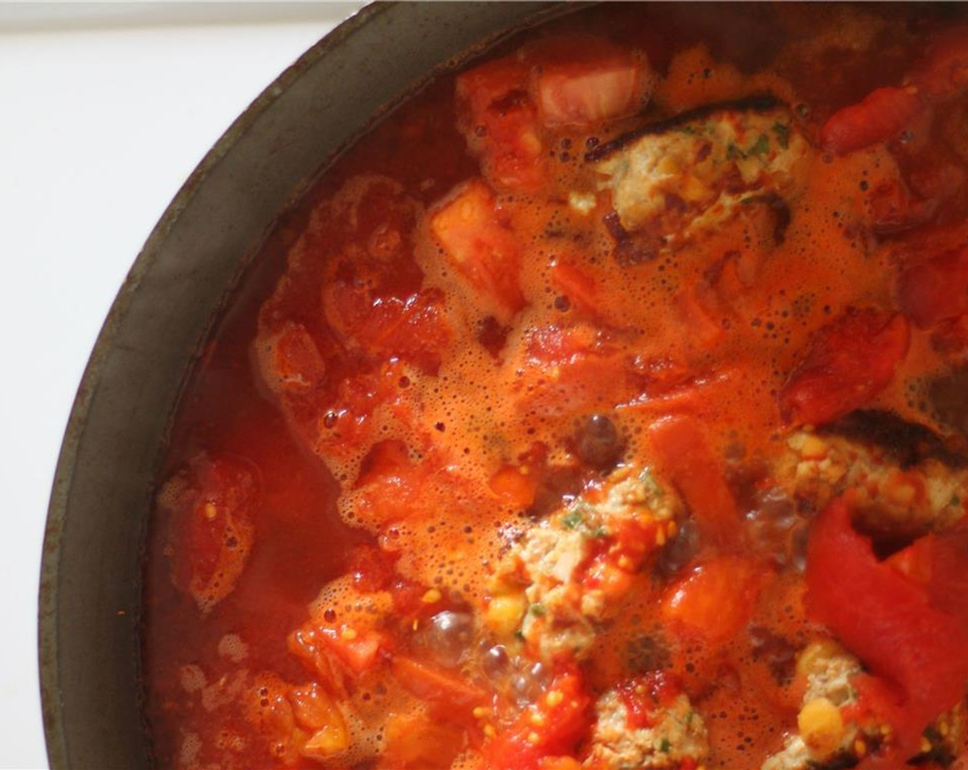 step 4 Turn down to medium-high heat and add the Roma Tomatoes (2). Allow to soften for a few minutes, and then add the  Whole Peeled Tomatoes (1 can) and Chicken Stock (1 cup). This should almost completely cover the meatballs.