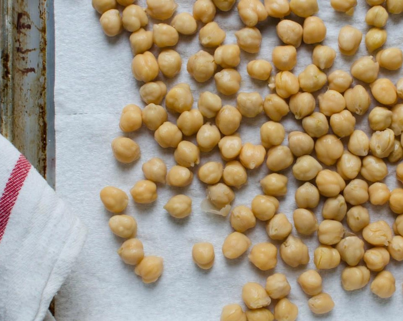step 3 Transfer the chick peas to the paper towels and scatter about, so that the towels soak up most of the moisture. Tear off another towel and gently pat and roll the chick peas until they are dry, removing any loose skins and discarding.