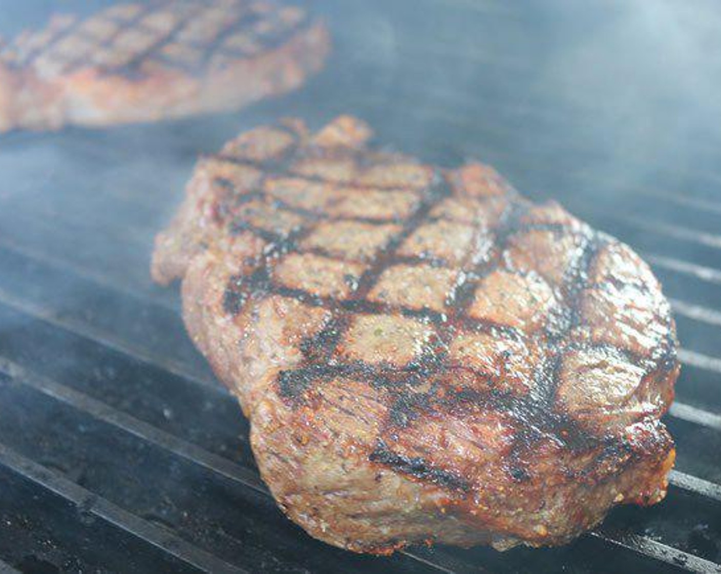 step 6 As soon as the grill is up to temperature place each steak on the grate.  Place the lid on and set a timer for 2 minutes. Give the steaks a 45⁰ twist after 2 minutes. Set the timer again and replace the lid.