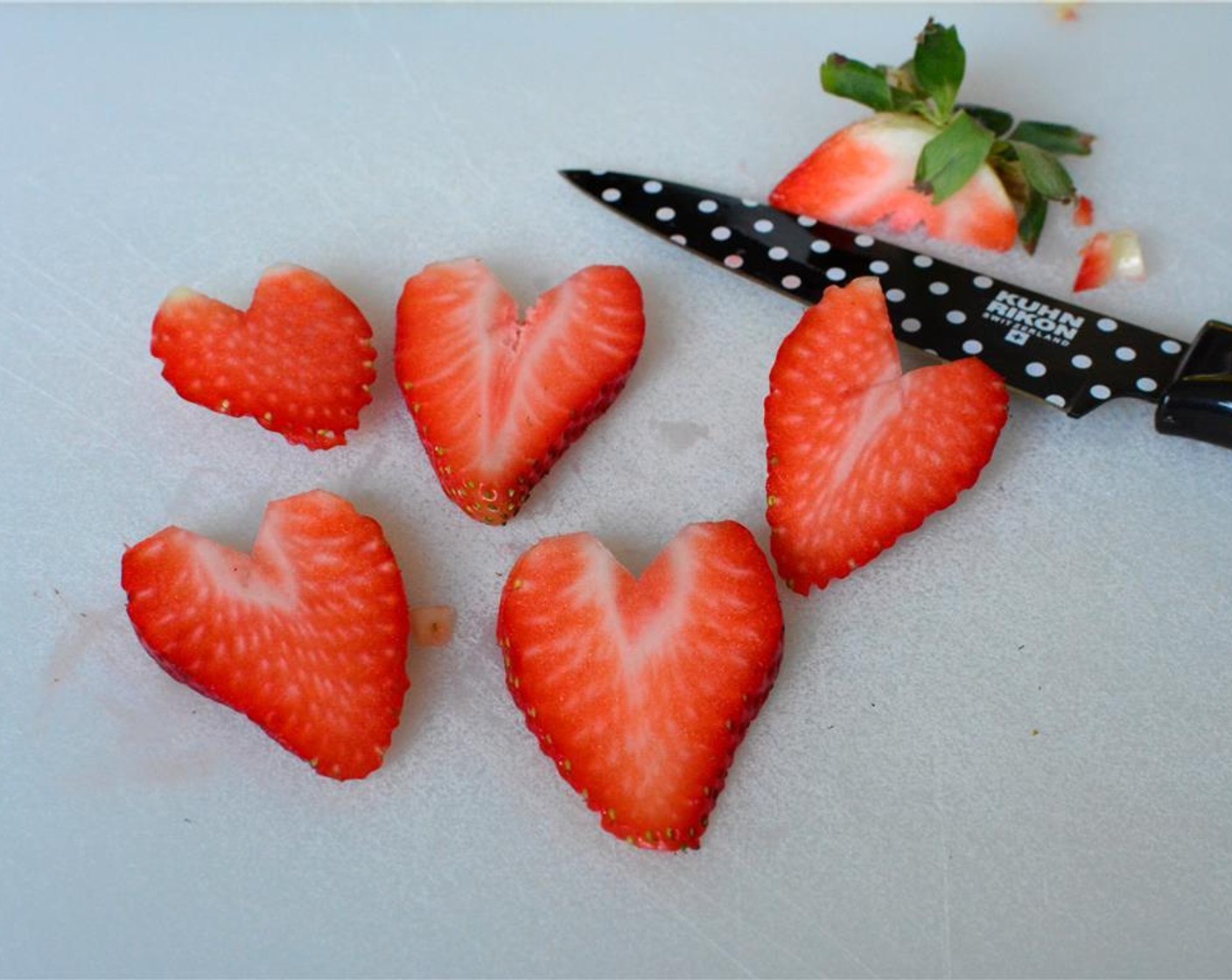 step 1 To make strawberry hearts for the garnish cut a small "v" to remove the stem of the Fresh Strawberries (2). Then cut it into slices.