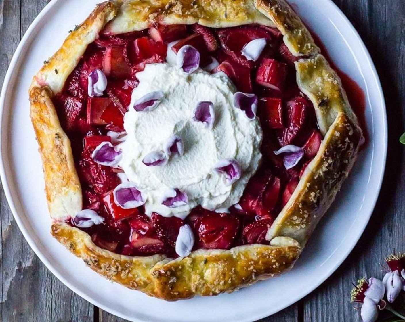 step 12 Serve each slice of cooled galette with a dollop of creme fraiche whipped cream and edible flower blossoms. Enjoy!