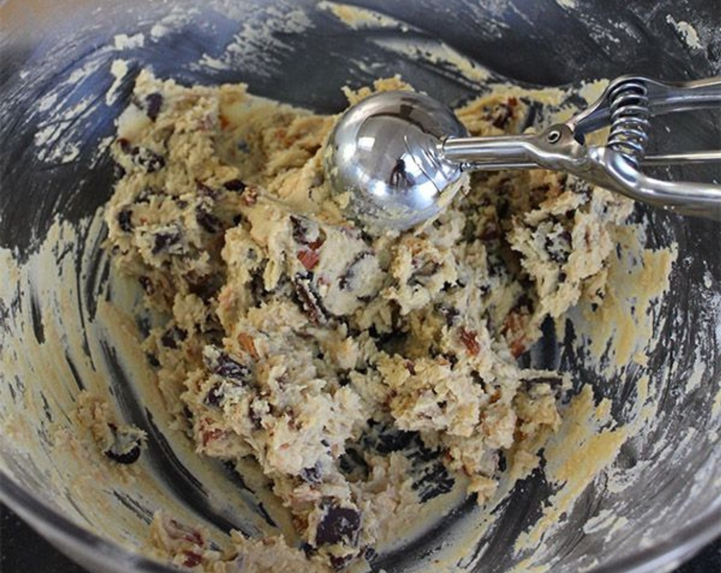 step 8 Using a 2¼-inch ice cream scoop or two spoons, form round balls of cookie dough about 2-inches in diameter. Place 9 balls of dough on each sheet pan, evenly spaced, and bake for 12-15 minutes, until just starting to turn golden brown and still soft to the touch. The cookies should seem under-baked; they will firm up as they cool.