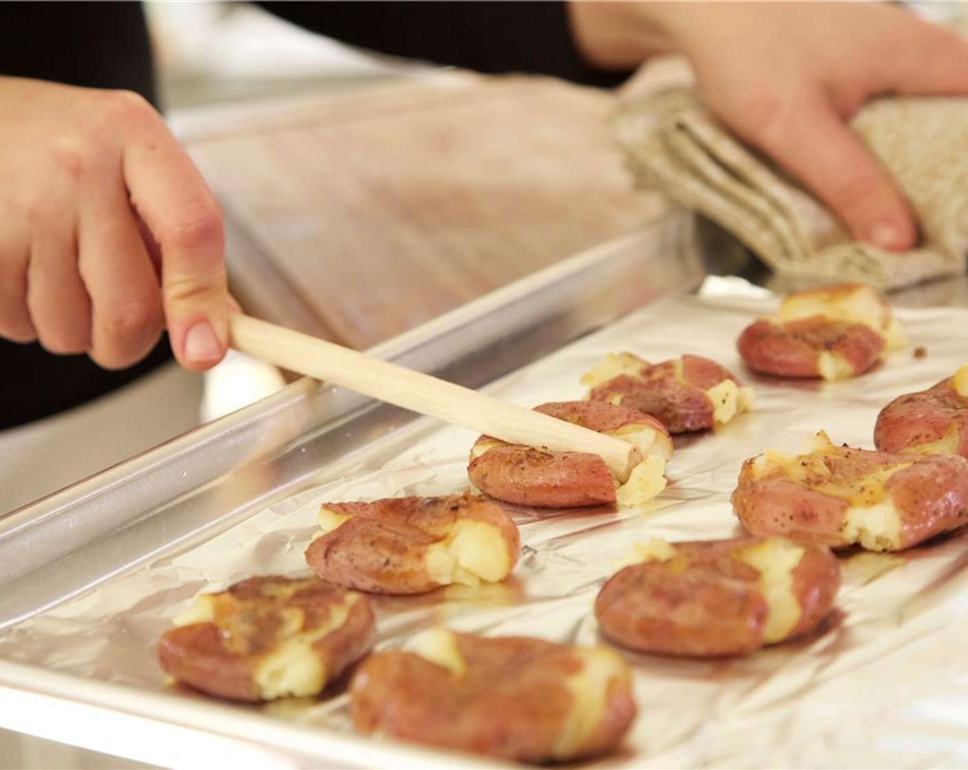 step 7 Remove the red potatoes from the oven. Open the packet. Separate the potatoes from the garlic. Using the back of a spoon, gently smash each potato, then smash the garlic. Top the potatoes with a bit of the smashed garlic and return to the oven, uncovered for 10 to 12.