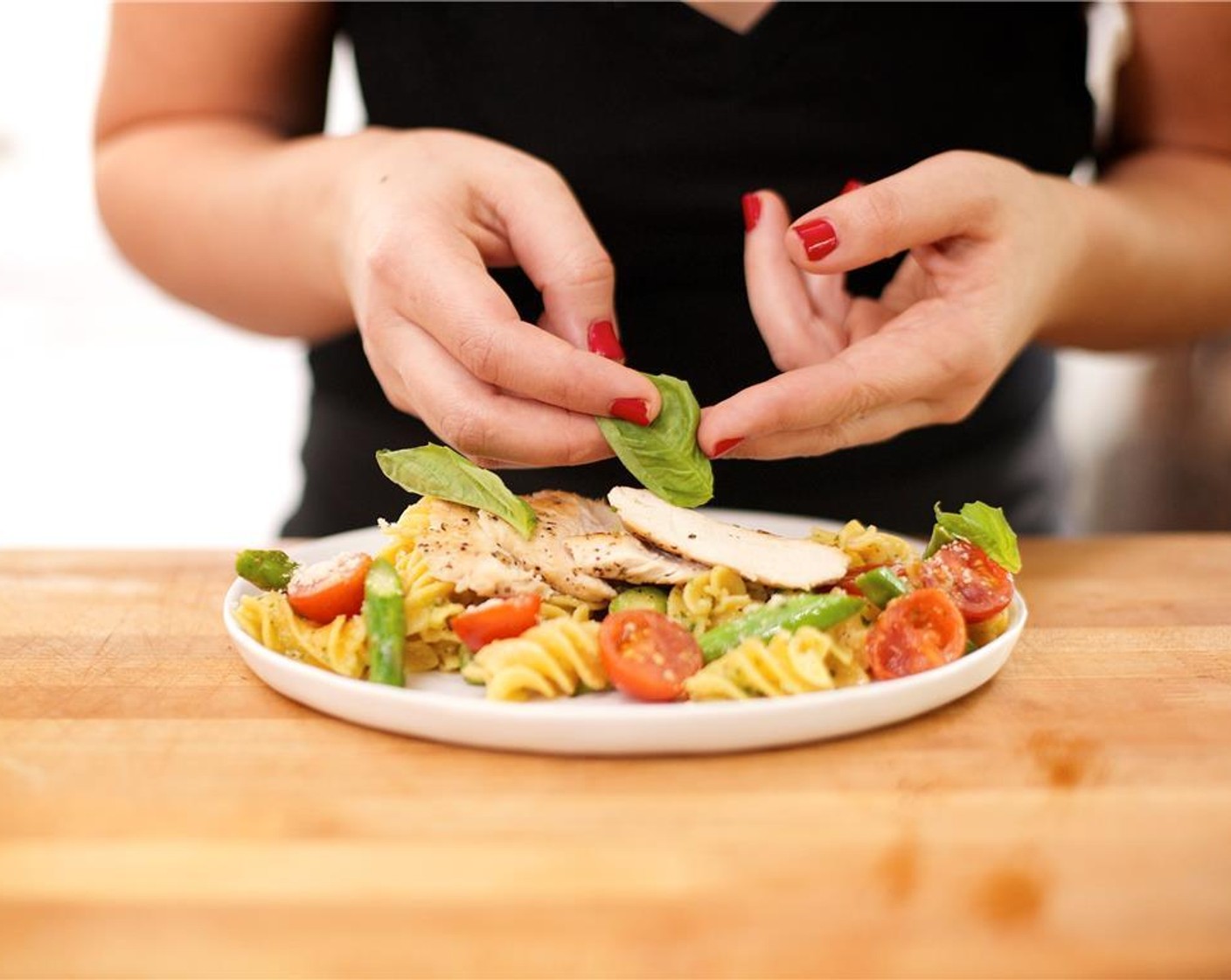 step 20 Slice the chicken breast into thin slices. Place the pasta and vegetable mixture onto the center of two plates. Fan out chicken breast over the pasta. Garnish with Parmesan Cheese (2 Tbsp).