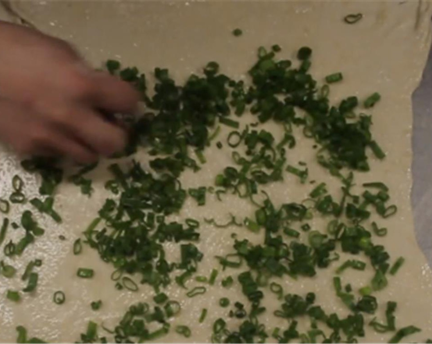 step 10 Sprinkle spring onion, white and green parts, across the dough.