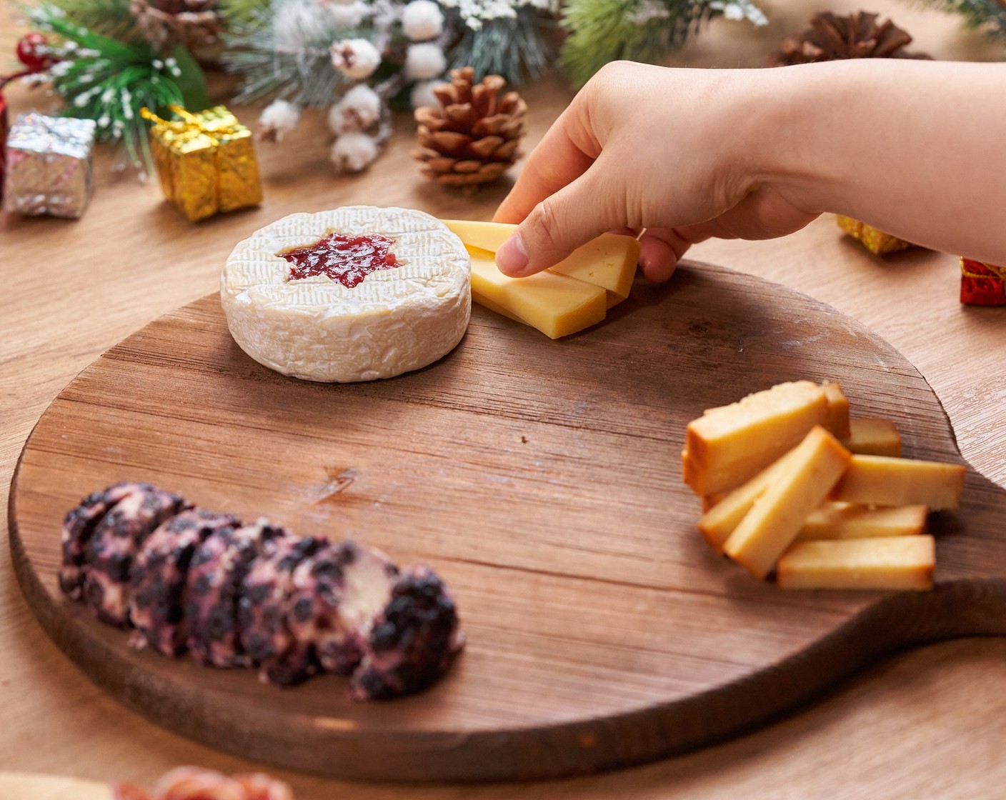 step 3 Place the Smoked Cheddar Cheese (3/4 cup), Gouda (1/2 cup), Cranberry Cinnamon Goat Cheese (1/2 cup), and Brie around the board.