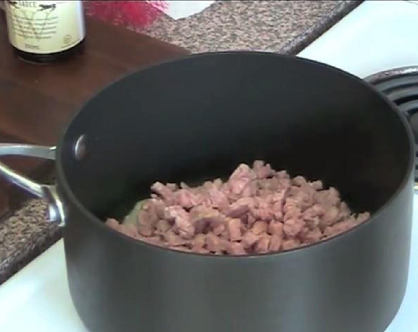 step 1 Into a pot, stir together the Garlic Infused Olive Oil (as needed), Yellow Onion (1), and Bacon (7 oz) over low heat.